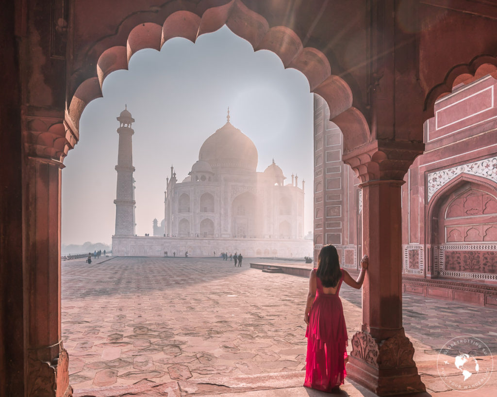 Girl standing against the Beautiful arches to frame the Taj Mahal
