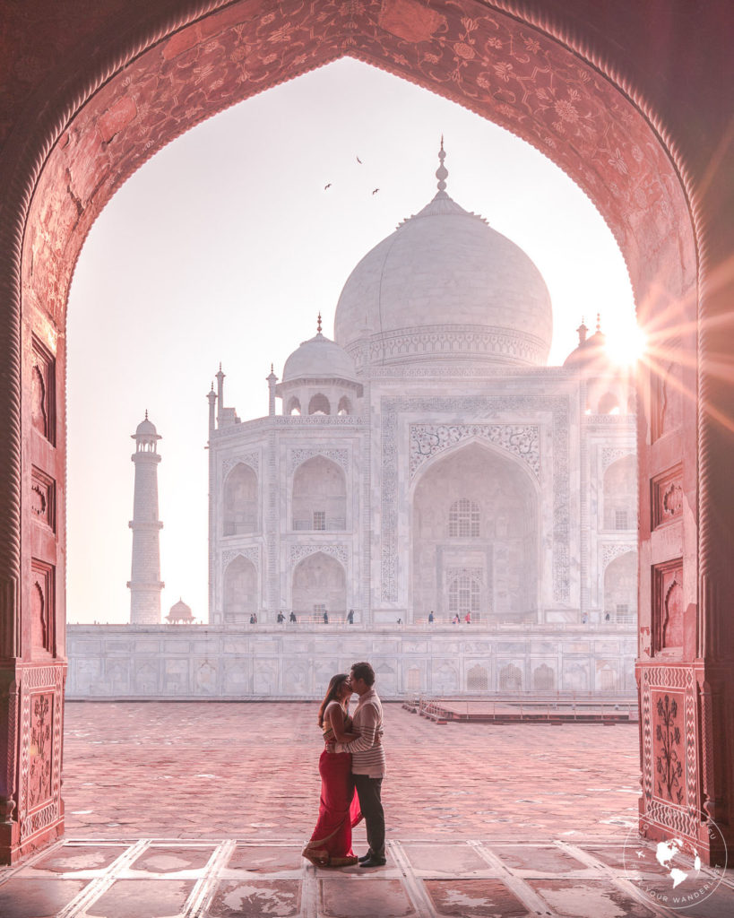 A couple kissing while the sun is rising over the Taj Mahal in Agra