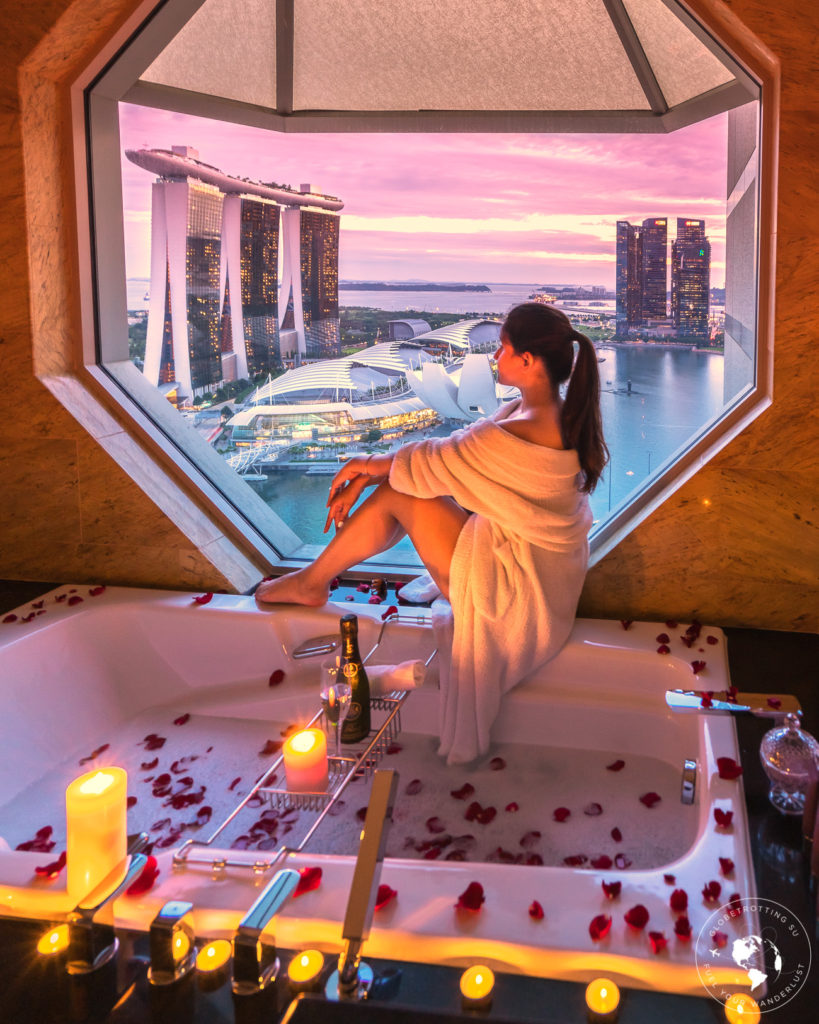 Girl looking at Marina Bay sands from her bathtub Ritz Carlton Millenia during sunset 