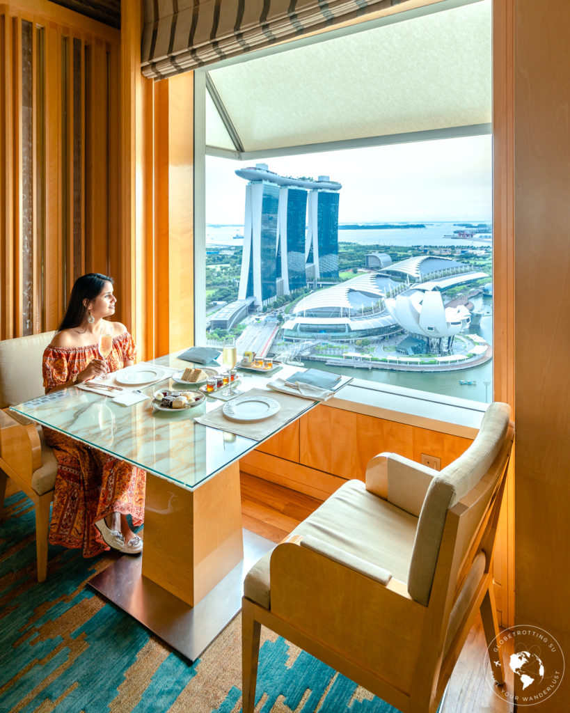 Girl enjoying free-flow Champagne while enjoying views of Singapore skyline at Club Lounge during afternoon tea 